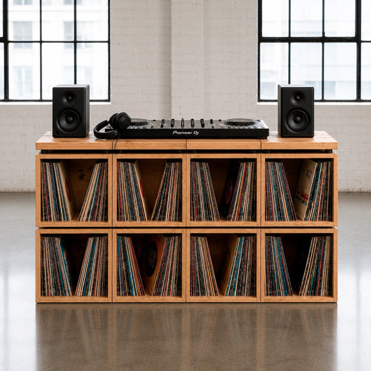 The Station turntable console — record player and speakers on the solid wood top, hundreds of LPs below