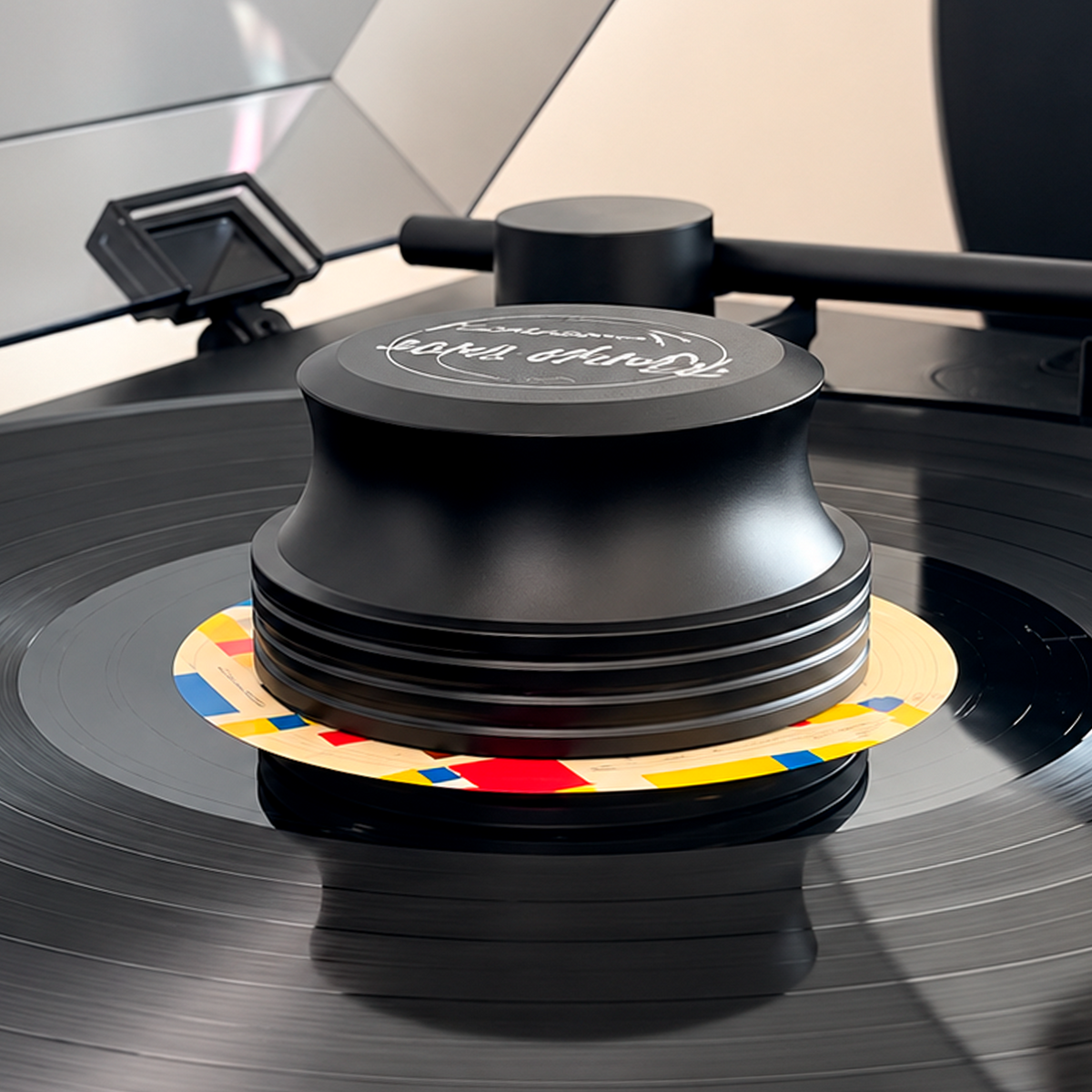 Black Vinyl Record Stabilizer pressing a record flat on the turntable platter