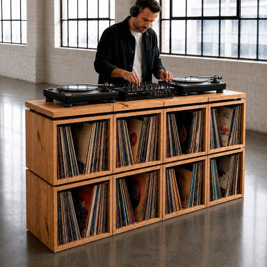 The Station solid wood turntable console in use — DJ playing records on the wood top above a wall of vinyl