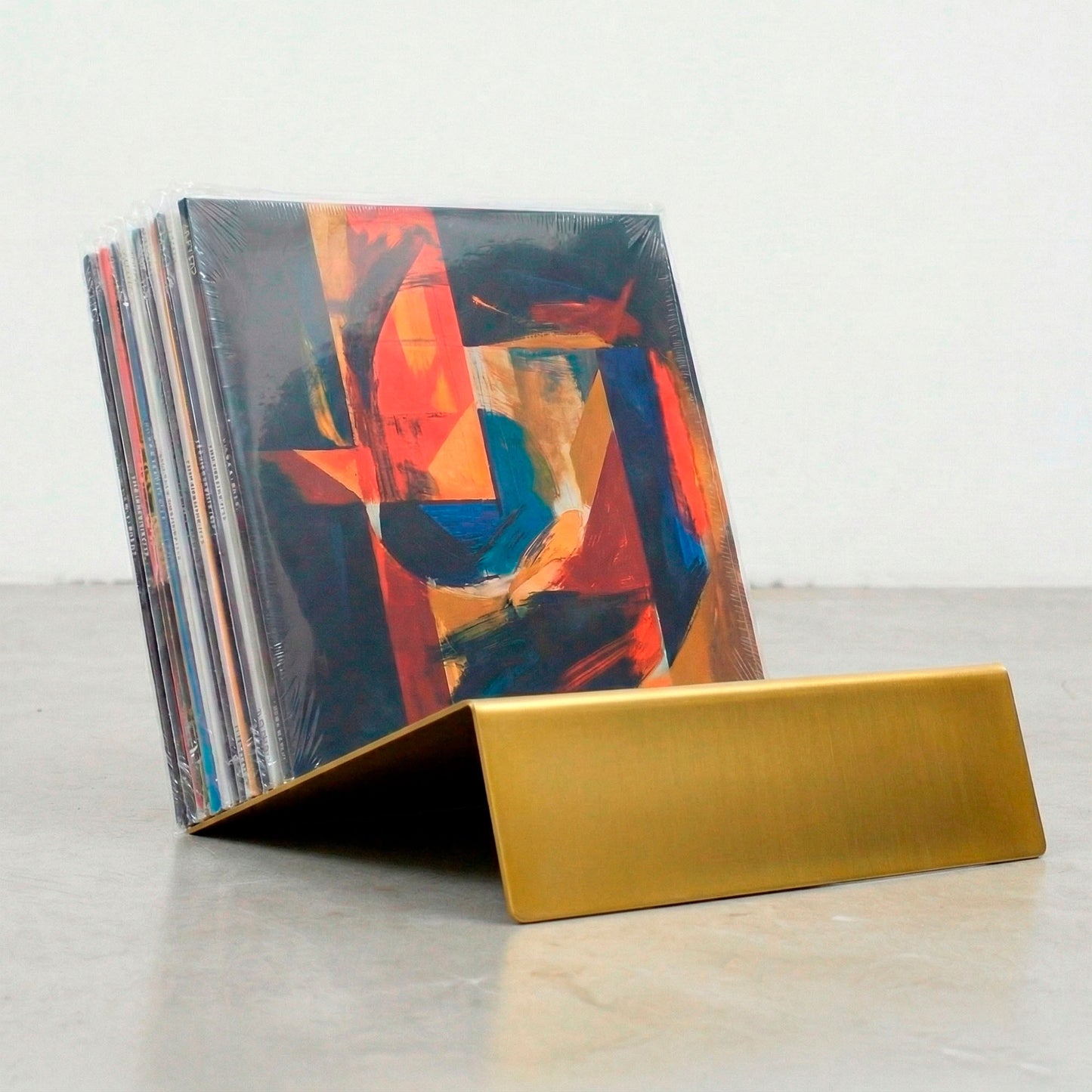 Gold powder-coated Vinyl Break record stand holding LP collection upright on concrete floor