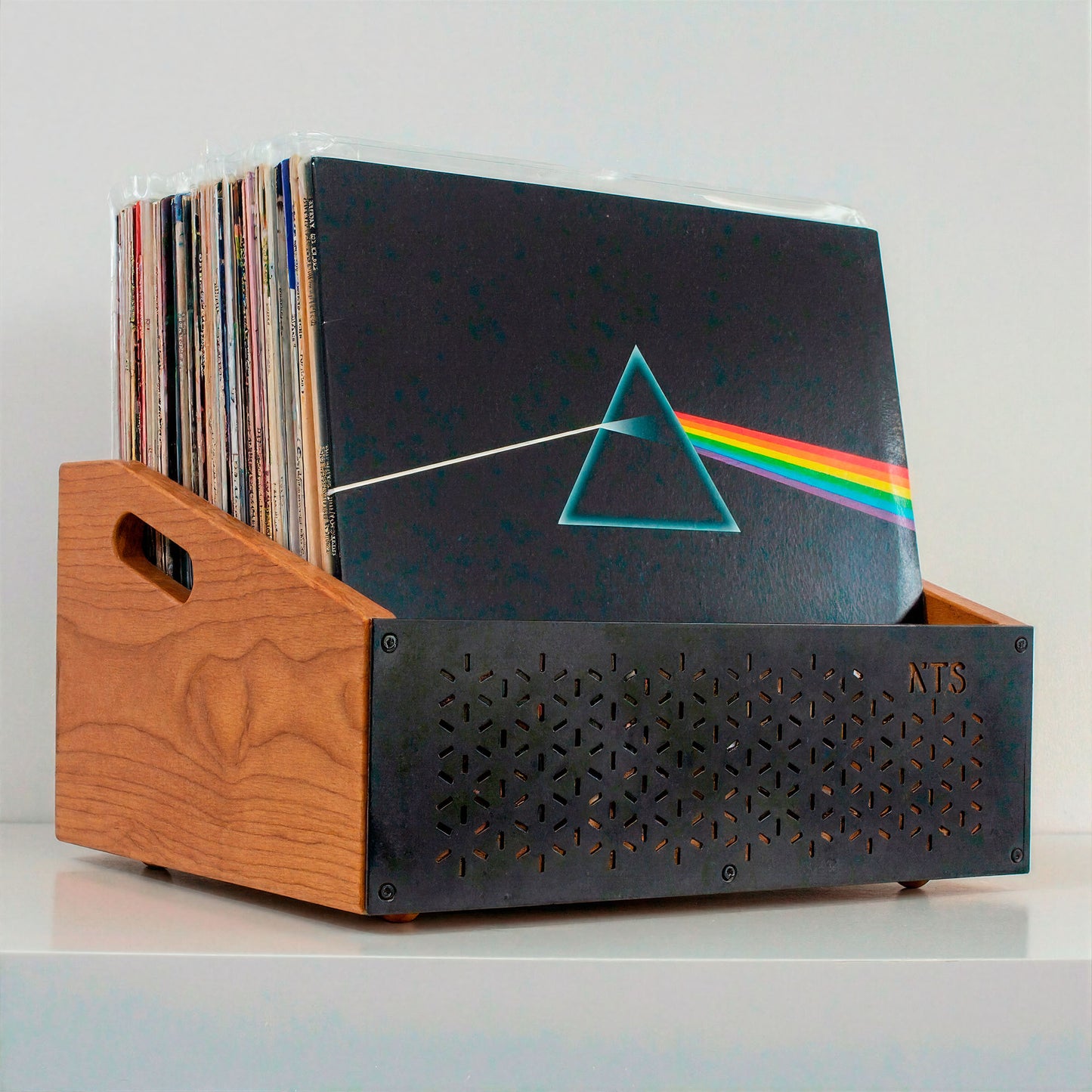 Organizador de discos de vinilo en madera sobre aparador, con tocadiscos y ambiente cálido en casa