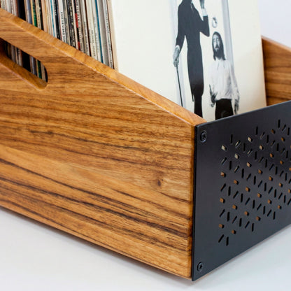 Detalle de soporte de vinilos de madera con lateral metálico negro, discos ordenados y fácil acceso