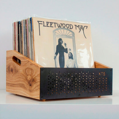 Hombre eligiendo un vinilo junto a tocadiscos y soporte de vinilos de madera en salón acogedor