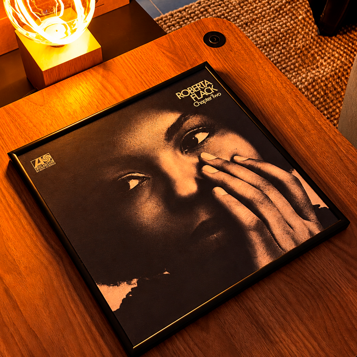 Black 12" album cover frame lying flat on a wooden table